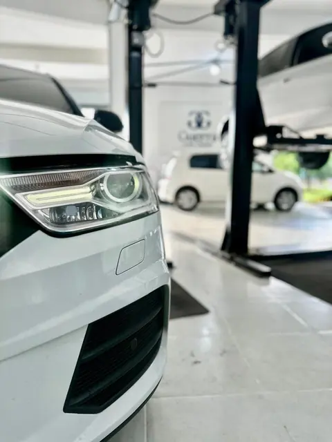 Detalhe do farol de um carro em revisão elétrica